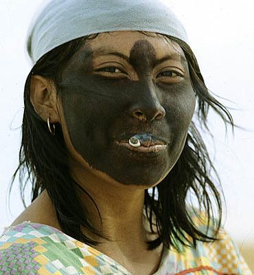 Colombia. Guajira Peninsula. Guajira Desert. Guajiro Indiian woman. She blackened her face with a powder extracted from a root to protect it against sunburn. She smokes her cigarette holding the lighted side inside her mouth.