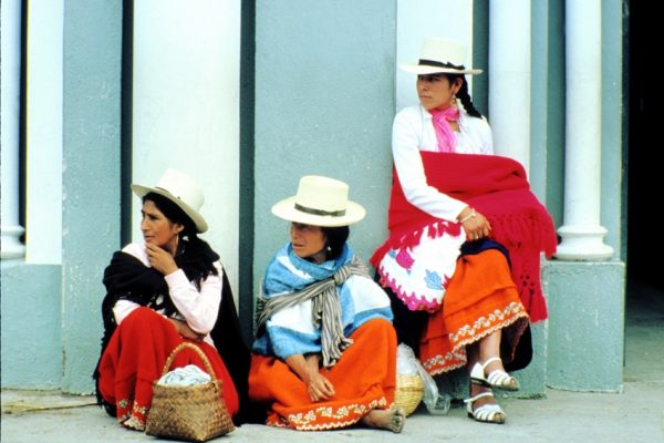 Ecuador. Cuenca. Mestizas sitting outside church on market day.